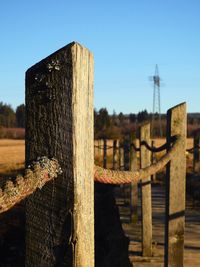 Close-up of wooden post against fence