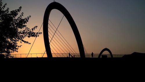 Low angle view of silhouette bridge against clear sky