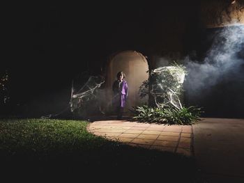 People standing by plants at night