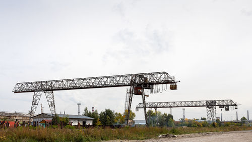 Low angle view of crane at construction site against sky