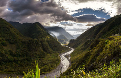 Scenic view of river and mountains against cloudy sky