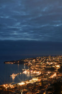 High angle view of illuminated cityscape against sky at night