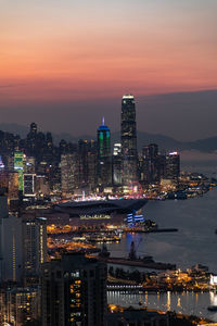 Illuminated buildings in city against sky at night