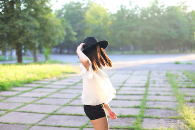 Full length of woman standing on footpath