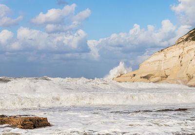 Scenic view of rocky beach against sky