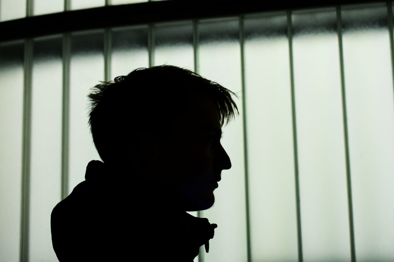 CLOSE-UP PORTRAIT OF SILHOUETTE MAN LOOKING AT WINDOW