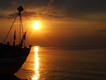 Silhouette boat at sea against sky during sunset