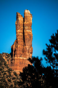 Low angle view of rock formation against clear blue sky