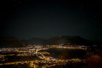 Illuminated city against sky at night