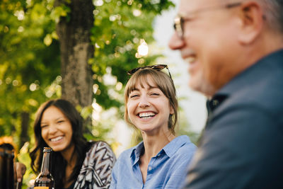 Male and female friends laughing at social gathering