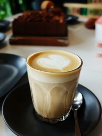 Close-up of heart shape froth art in latte on table