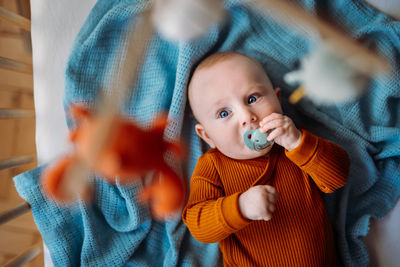 Portrait of cute baby boy lying on bed