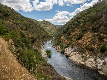 Scenic view of river amidst mountains against sky