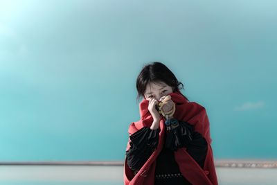 Portrait of girl holding ice cream against sky
