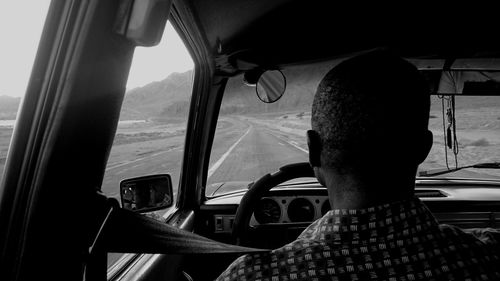 Rear view of man sitting in car