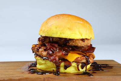 Close-up of burger on table against white background