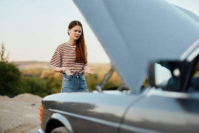 Side view of woman holding car