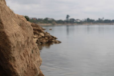 Rock formation on beach against sky