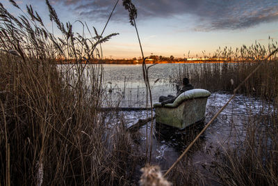 Man in armchairs on lakeshore