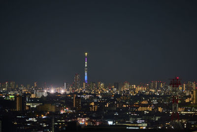 Illuminated cityscape against sky at night