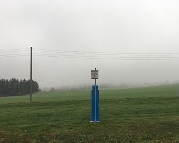 Wind turbines on field against sky