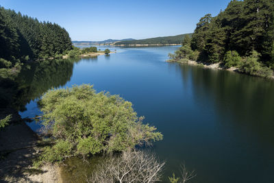 Scenic view of lake against clear blue sky