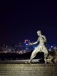 Statue in city at night