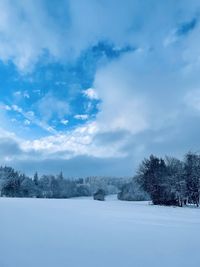 Scenic view of snow covered land against sky