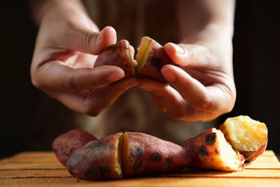 Close-up of hand holding bread on table