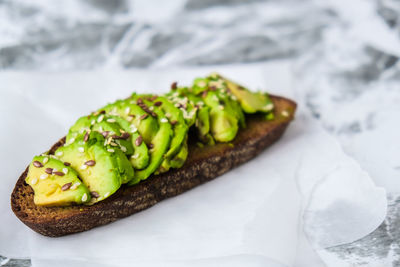 Healthy avocado toast on concrete background. wholegrain bread, sesame flax seeds. vegan keto diet. 