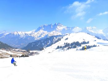 People skiing on snowcapped mountain against sky