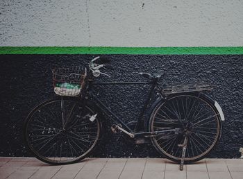 Bicycle parked on wall by street