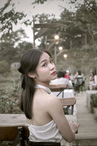 Side view of young woman sitting at park