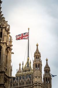 Low angle view of british flag on houses of parliament against sky