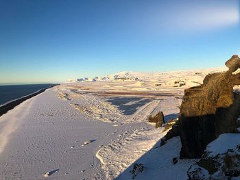 Scenic view of sea against clear blue sky during winter