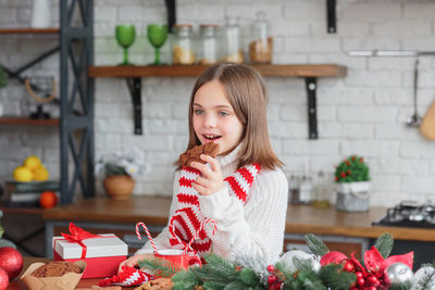 Cute smiling little child girl eating chocolate biscuits and drinking hot cocoa