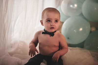 Portrait of cute baby boy on bed at home