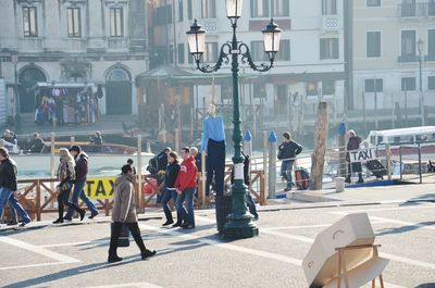 People walking on road along buildings