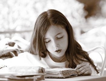 Portrait of a young woman reading book