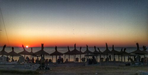 Scenic view of beach against clear sky during sunset