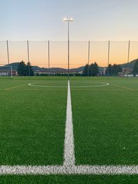 Scenic view of soccer field against sky during sunset