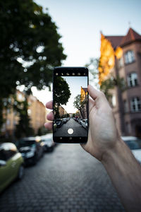 Hand holding mobile phone in city