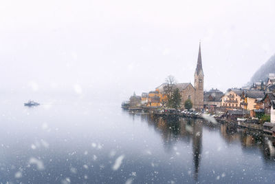 River in city against clear sky during winter