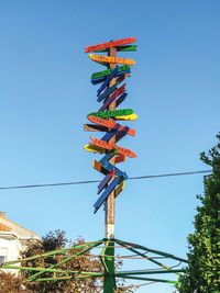 Low angle view of lanterns hanging against clear blue sky