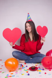 Young woman with heart shaped balloons