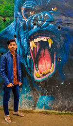 Full length portrait of man standing against wall