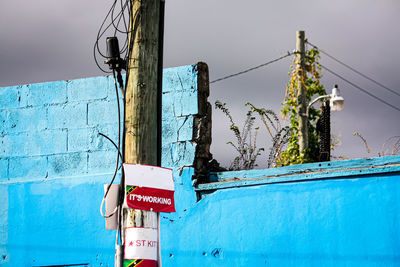 Information sign on pole against blue sky