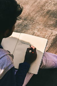 High angle view of man making face on paper