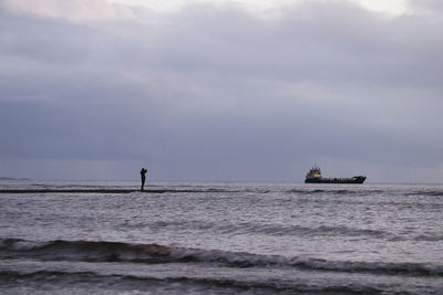 Silhouette ship in sea against sky