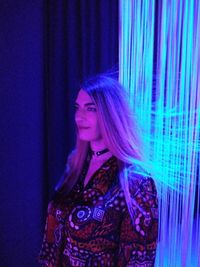 Young woman wearing mask against blue background